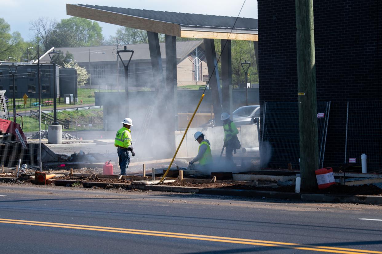 Two construction workers prepare the sidewalk for the Dr. Ernest Rip Patton Jr. North Nashville Transit Center, on Clarksville Pike and 26th Avenue North in Nashville, Tenn., Wednesday, April 3, 2024.