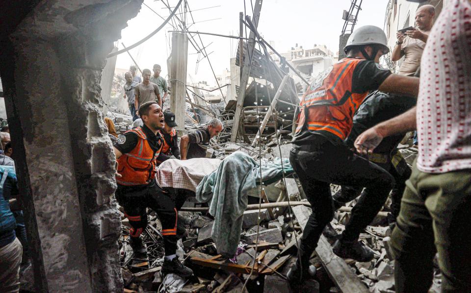 Civil defense teams and residents launch a search and rescue operation around buildings that were destroyed or heavily damaged as Israel's attacks on the Gaza Strip continue on its eighth day in Khan Yunis, Gaza on October 14, 2023.