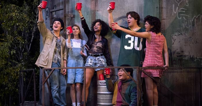 The cast of That 90s Show toast with red Solo cups on the water tower