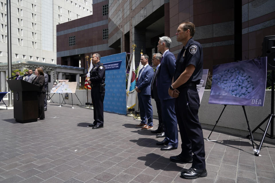 Officials stand behind Acting United States Attorney Tracy Wilkison, far left at podium, outside the Edward R. Roybal Federal Building, Thursday, May 13, 2021, in Los Angeles. Federal authorities say they have arrested at least 10 suspected drug dealers accused of selling fentanyl and other opioids that led to overdose deaths. (AP Photo/Marcio Jose Sanchez)