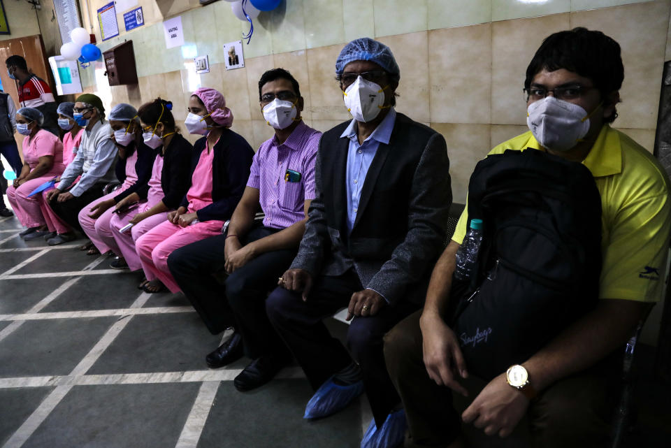 First batch of health workers wait for their turn to get vaccinated at a hospital in Kolkata, India, Saturday, Jan. 16, 2021. India started inoculating health workers Saturday in what is likely the world's largest COVID-19 vaccination campaign, joining the ranks of wealthier nations where the effort is already well underway. (AP Photo/Bikas Das)