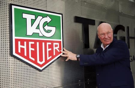 Jean-Claude Biver, head of French luxury goods group LVMH's watch business and interim CEO of the group's biggest watch brand, TAG Heuer, poses in front of the company's logo before a news conference in the western Swiss town La Chaux-de-Fonds December 16, 2014. REUTERS/Arnd Wiegmann