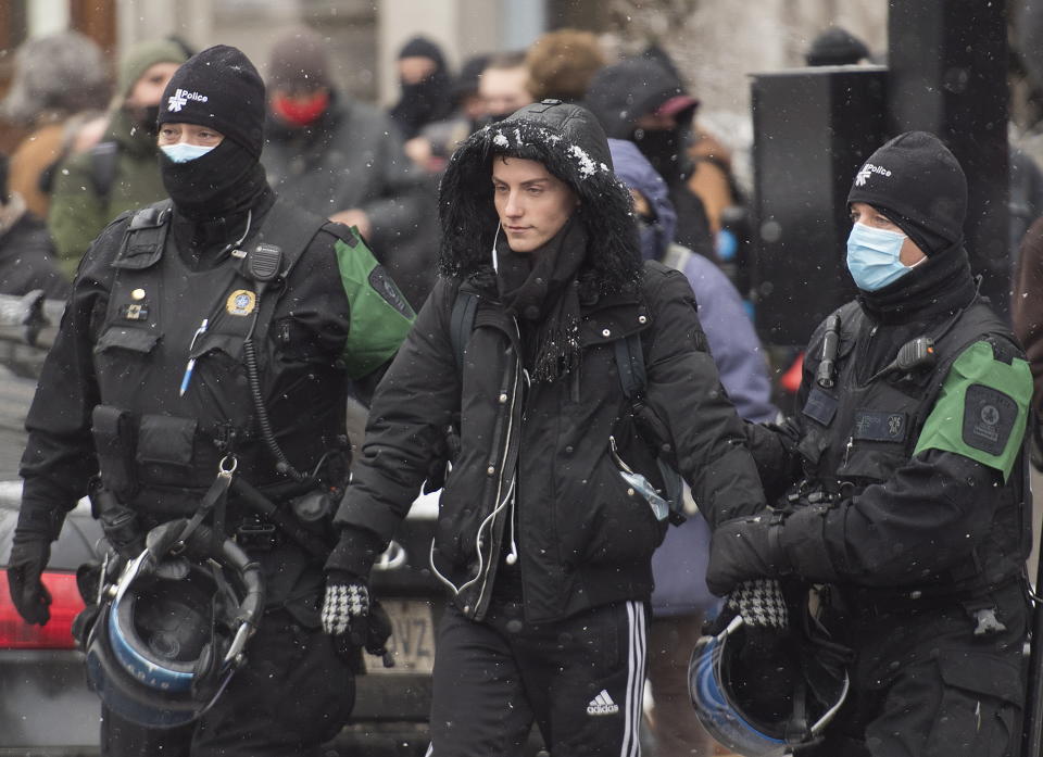 Police detain a person during a demonstration in Montreal, Sunday, Dec. 20, 2020, where people protested measures implemented by the Quebec government to help stop the spread of COVID-19. The COVID-19 pandemic continues in Canada and around the world. (Graham Hughes/The Canadian Press via AP)