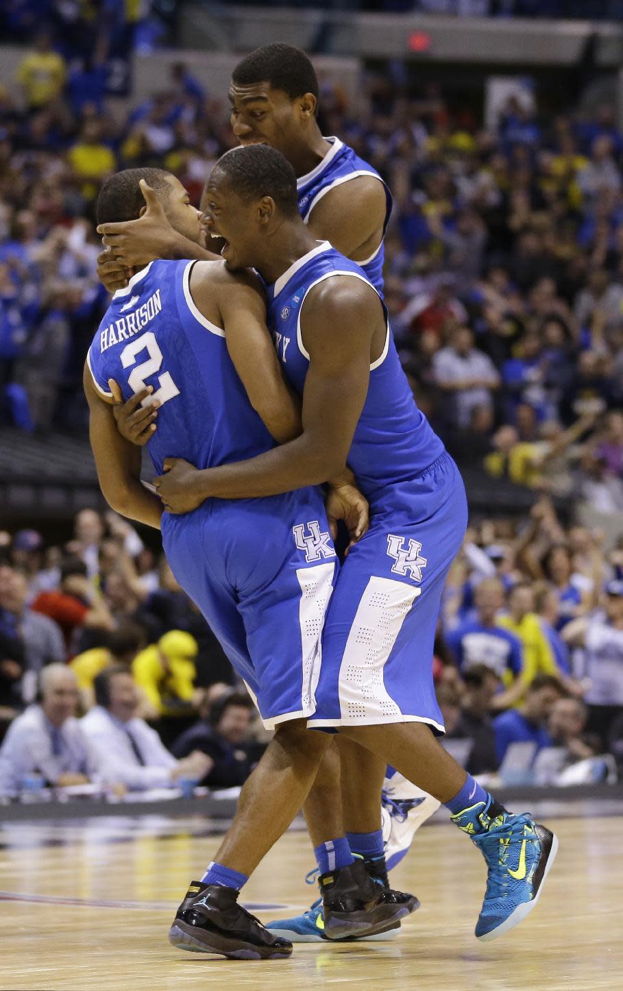 Kentucky's Aaron Harrison (2) is congratulated by teammates Julius Randle and Dakari Johnson after making a three-point basket in the final seconds of the second half of an NCAA Midwest Regional final college basketball tournament game against Michigan Sunday, March 30, 2014, in Indianapolis. Kentucky won 75-72 to advance to the Final Four. (AP Photo/Michael Conroy)