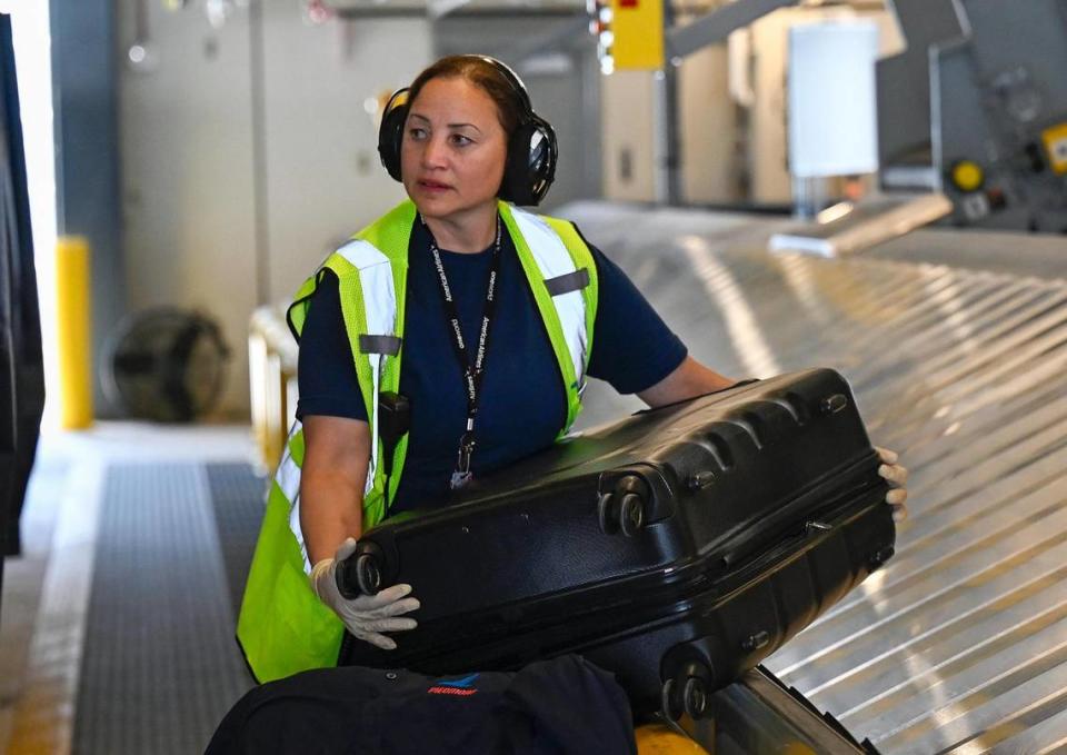 Ramp agent ValVilla De La Cruz pulls a bag from the conveyor at the new KCI terminal.