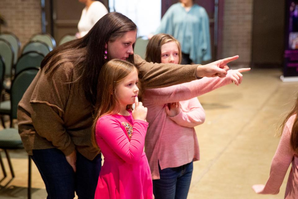 Hailey David points at a wedding dresses on display with her daughters Sadie David, 9, and Emma David, 6, during the Jackson Bridal Show at Carl Perkins Civic Center on Sunday, January 8, 2023, in Jackson, Tenn. 