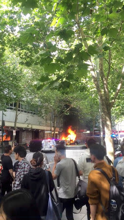 A burning car is seen on Bourke Street, in Melbourne, Australia, November 9, 2018 in this picture grab obtained from social media video. WILL MITCHELL/via REUTERS