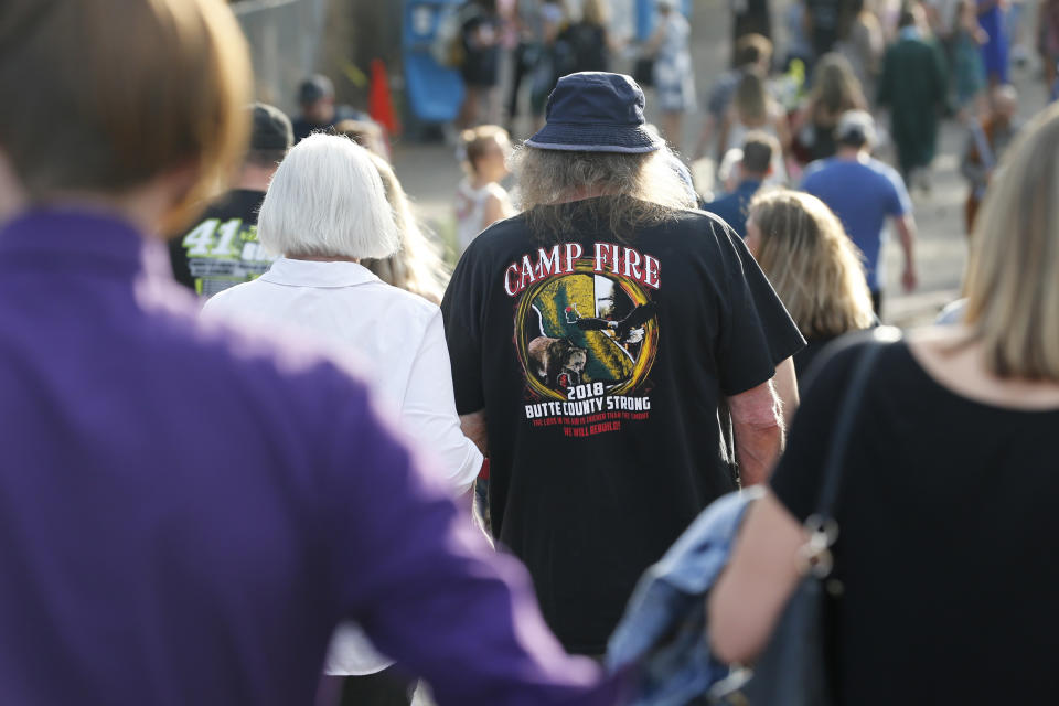 Garry Reynolds wears a reminder of the Camp Fire as he attends graduation ceremonies where his granddaughter received her diploma at Paradise High School in Paradise, Calif., Thursday June 6, 2019. Most of the students of Paradise High lost their homes when the Camp Fire swept through the area and the school was forced to hold classes in Chico. The seniors gathered one more time at Paradise High for graduation ceremonies. (AP Photo/Rich Pedroncelli)