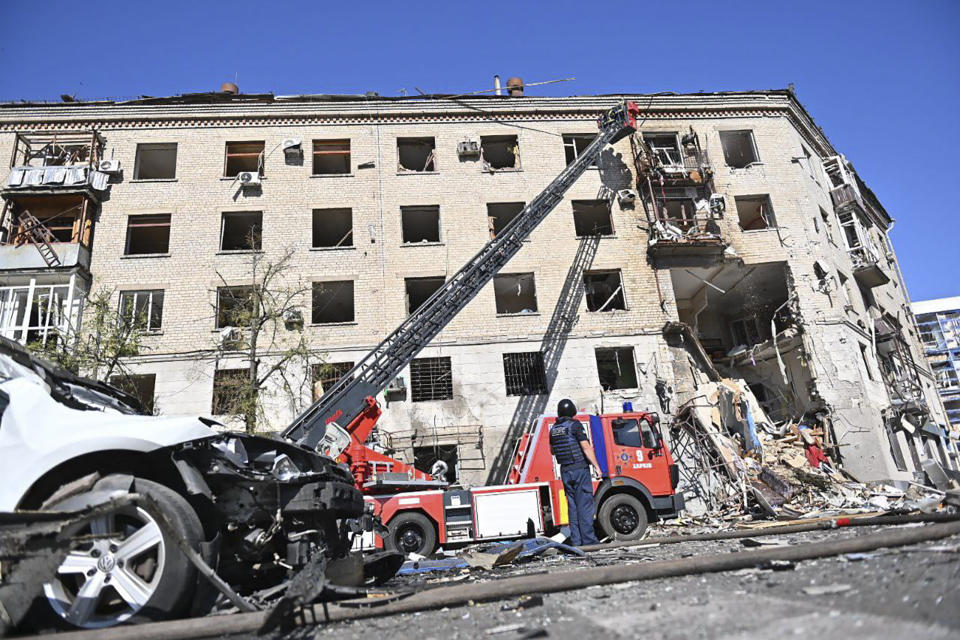 In this photo provided by the Ukrainian Emergency Service, rescuers work in a damaged apartment house after it was hit by Russian air bomb killing at least three and injuring 23, in Kharkiv, Ukraine, Saturday, June 22, 2024. (Ukrainian Emergency Service via AP)