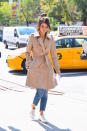 <p>Switching to a lighter color palette, Gomez returned to set in a khaki trench coat over light jeans and white sneakers. (Photo: Getty Images) </p>