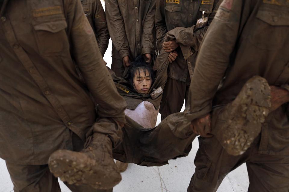 Students carry female trainee who has fallen into a stupor during high intensity training at Tianjiao Special Guard/Security Consultant camp on the outskirts of Beijing