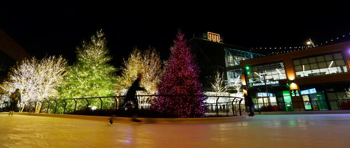 Ice skaters on Hy-Vee Plaza pass by lights on display in the Titletown District. The rink hosts Glow Nights with multicolored lights from 4 to 8 p.m. Thursdays through Feb. 23.