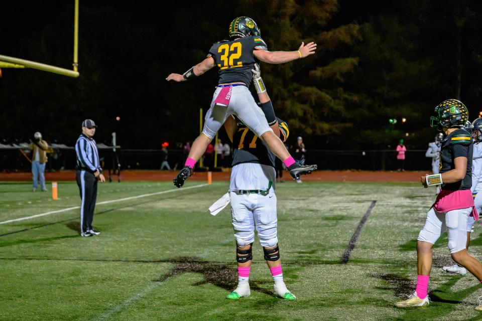 Rock Bridge's Carter DeVore (77) lifts ups Cooper Myers (32) in celebration after he scored a Bruins' touchdown during a game at Rock Bridge High School on Oct. 6, 2023, in Columbia, Mo.
