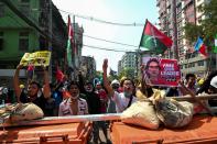 FILE PHOTO: Protesters flash three-finger salutes during a rally against the military coup in Yangon