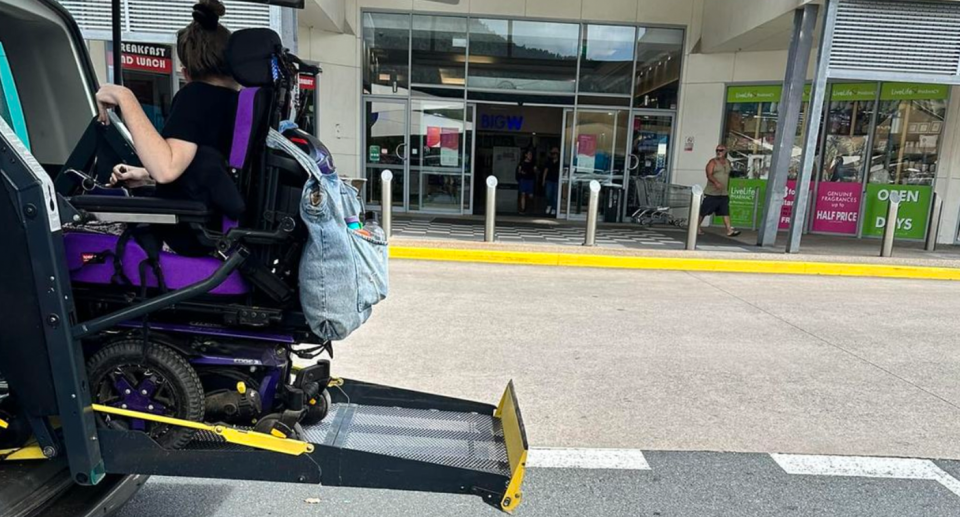A Queensland woman is seen exiting a vehicle in a wheelchair. 