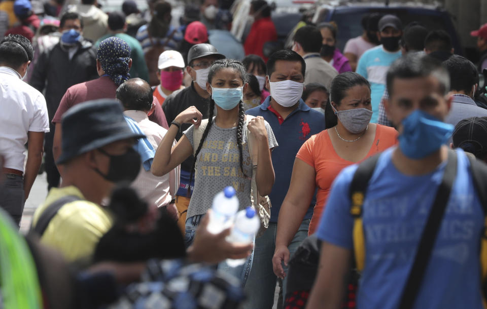 Personas con mascarillas caminan por el centro de la capital en medio de la nueva pandemia de coronavirus en Quito, Ecuador, el lunes 29 de junio de 2020. (AP Foto/Dolores Ochoa)