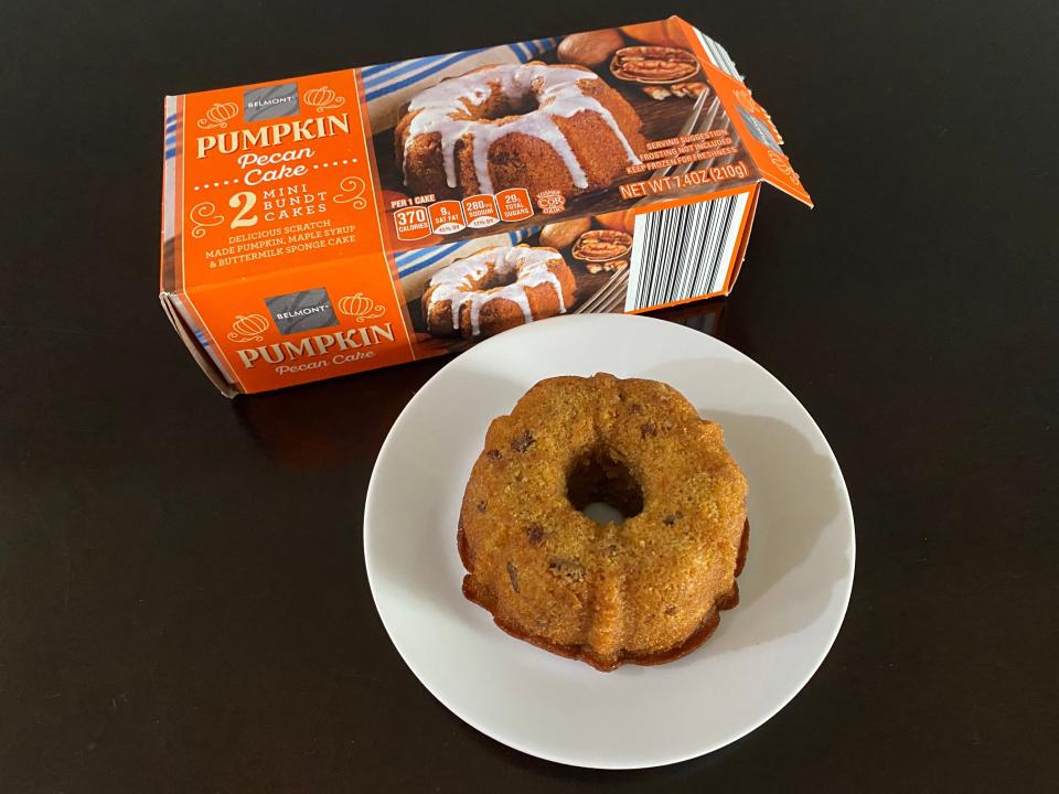 orange box of aldi pumpkin bundt cake beside cooked cake on white plate