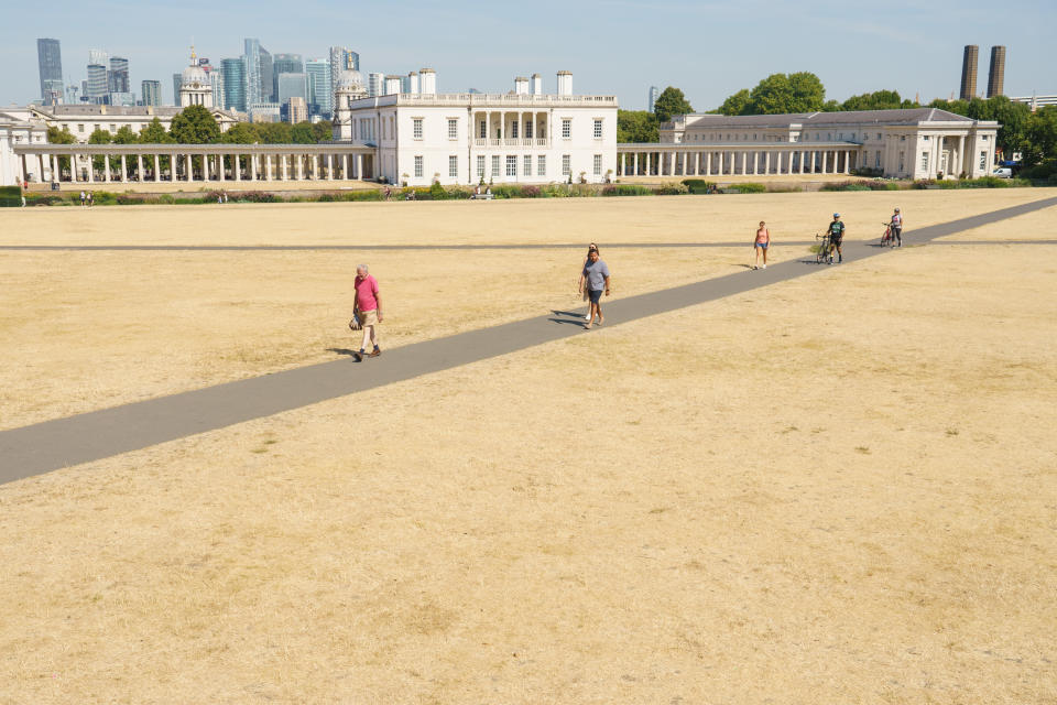 People walk past the Queen's House and Old Naval College, in Greenwich Park, London, as a drought has been declared for parts of England following the driest summer for 50 years. Picture date: Sunday August 14, 2022.