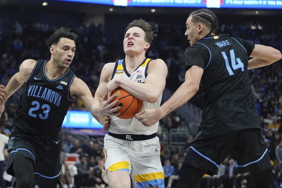 Marquette's Tyler Kolek drives by Villanova's Tyler Burton and Lance Ware during the first half of an NCAA college basketball game Monday, Jan. 15, 2024, in Milwaukee. (AP Photo/Morry Gash)