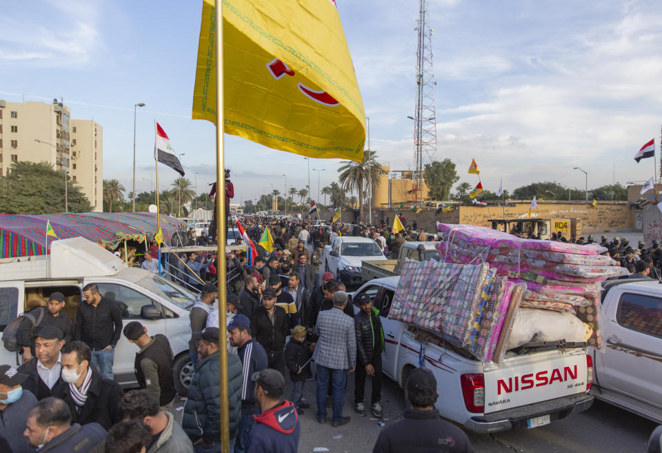 Pro-Iranian militiamen and their supporters load trucks with items that were used in a sit-in at the U.S. embassy, in Baghdad, Iraq, Wednesday, Jan. 1, 2020. U.S. troops fired tear gas on Wednesday to disperse pro-Iran protesters who were gathered outside the U.S. Embassy compound in Baghdad for a second day. (AP Photo/Nasser Nasser)