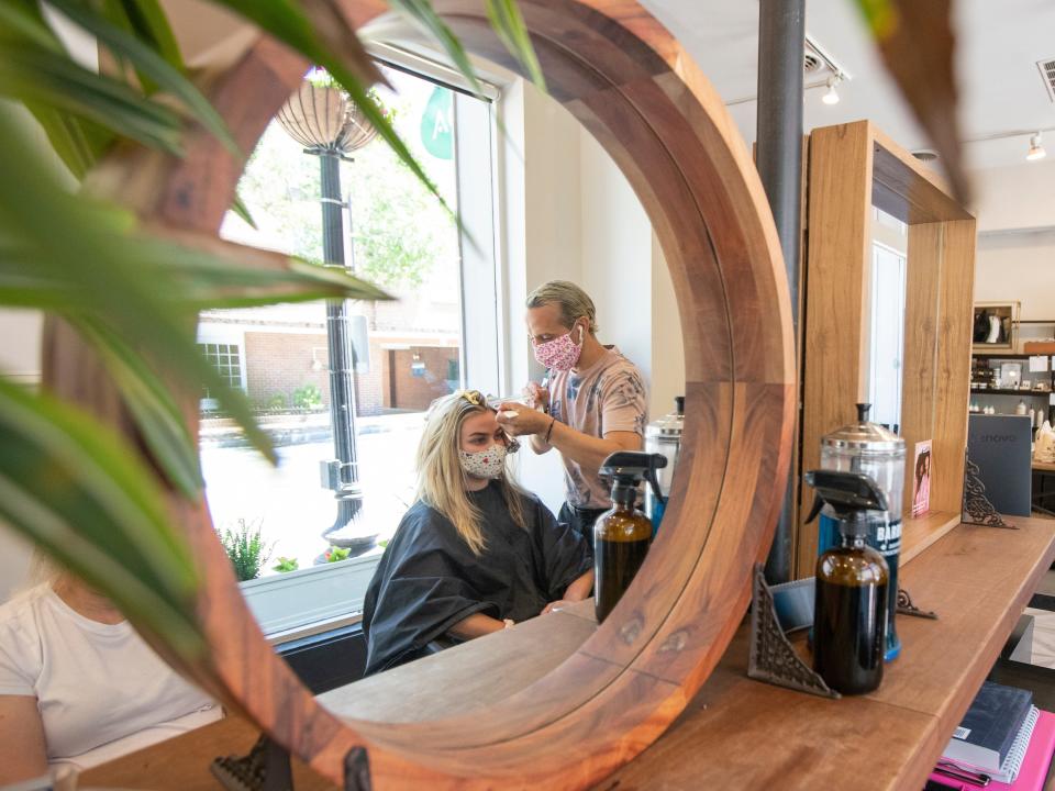 FILE- In this June 1, 2020, file photo hair stylist Zak Moukhtabir works on the hair of Cheyenne Foster at the Georgetown Salon & Spa in Washington.  The Trump administration does not have to issue an emergency rule requiring employers to protect workers from the coronavirus, a federal appeals court ruled Thursday, June 11. (AP Photo/Manuel Balce Ceneta, File)