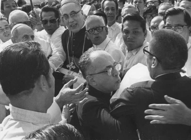 Msgr. Pasquale Macci (C), private secretary to Pope Paul VI, pushes away a crew-cut, cassock-clad man (R) trying to attack the pope with a knife at the airport in Manila, Philippines, shortly after the Pope’s arrival on November 27, 1970. UPI File Photo