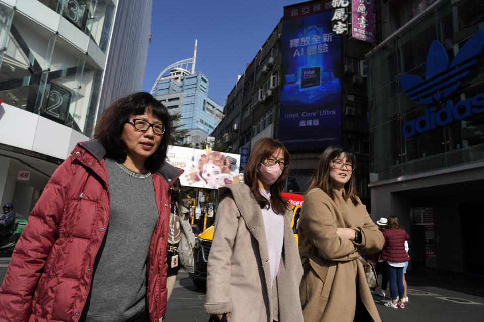 Visitors walk past by the Ximengding retail street in Taipei, Taiwan Thursday, Jan. 11, 2024. Beijing's threats to use force to claim self-governed Taiwan aren't just about missiles and warships. Hard economic realities will be at play as voters head to the polls on Saturday, though the relationship is complicated. (AP Photo/Ng Han Guan)