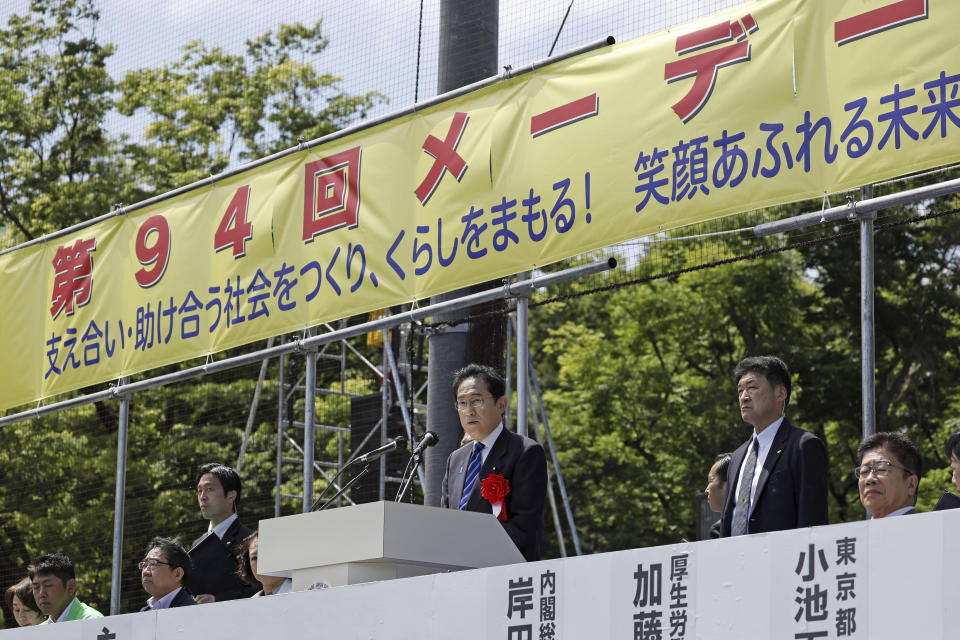 Japan's Prime Minister Fumio Kishida, center, delivers his speech at an May Day event in Tokyo Saturday, April 29, 2023. In Japan, May Day celebrations in Tokyo and elsewhere were held over the weekend without any pandemic-related restrictions for the first time in four years. The banner reads " The 94th May Day." (Kyodo News via AP)