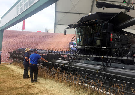 FILE PHOTO: Farmers look at a large grain harvester during the Agrishow farm equipment fair in Ribeirao Preto, Brazil, May 1, 2019. Picture taken May 1, 2019. REUTERS/Marcelo Teixeira/File Photo