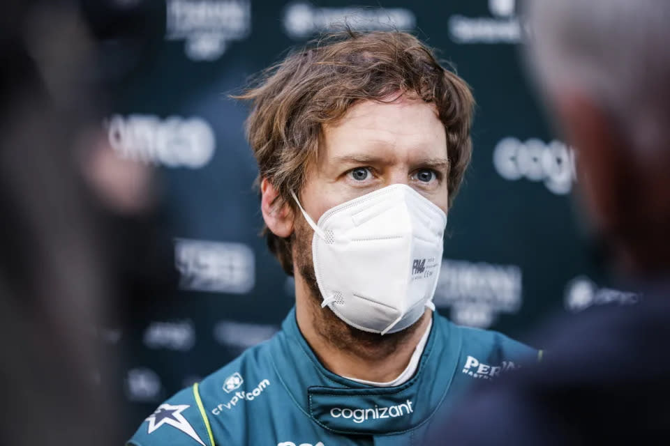 Sebastian Vettel is seen here wearing a mask speaking to reporters.