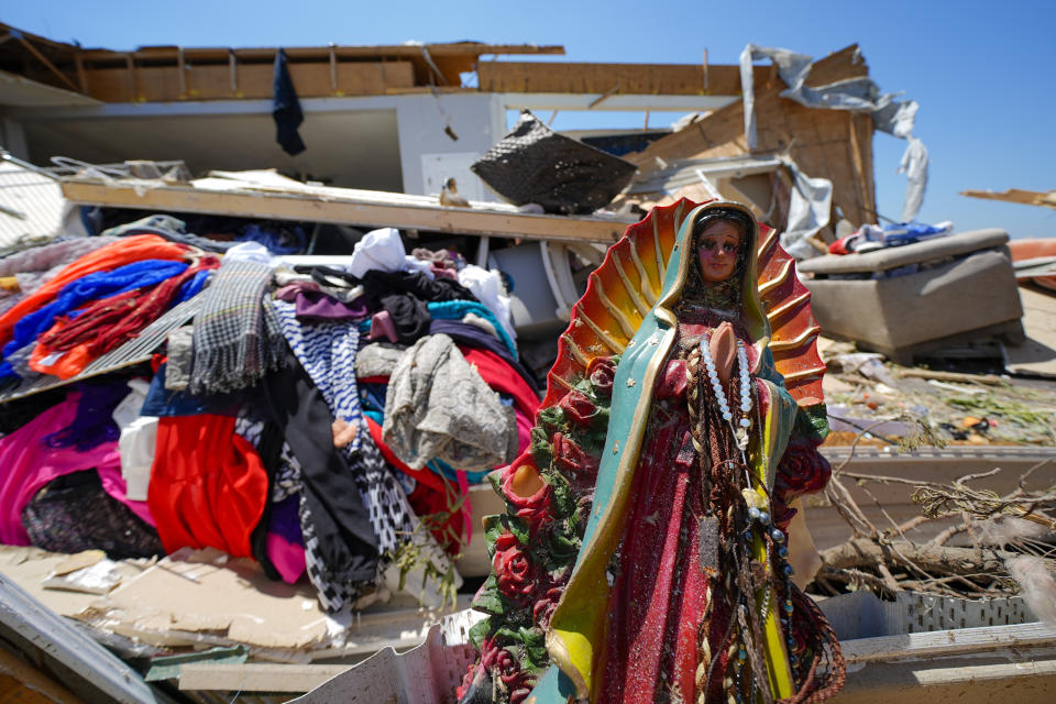 Una estatua de la Virgen de Guadalupe entre los escombros de la casa destruida de Juana Landeros, quien sobrevivió un tornado mortal con su esposo y su hijo de 9 años cuando atravesó la zona la noche previa, el domingo 26 de mayo de 2024 en Valley View, Texas. (AP Foto/Julio Cortez)