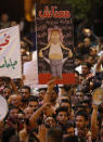 <p>Demonstrators hold up posters in front of Jordanian policemen during a protest near the prime minister’s office in Amman, Jordan, on June 6, 2018. Jordanian Prime Minister Hani Mulki resigned on June 4 after a wave of anti-austerity protests by citizens suffering from high unemployment and repeated price hikes. (Photo: Ahmad Gharabli/AFP/Getty Images) </p>