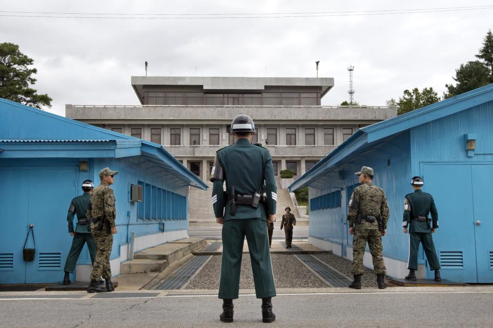 South Korean soldiers look towards the North Korean side as a North Korean solder approaches the U.N. truce village building that sits on the border of the Demilitarized Zone (DMZ), the military border separating the two Koreas, during the visit of U.S. Secretary of Defense Chuck Hagel, in Panmunjom, South Korea September 30, 2013. Hagel toured the Korean DMZ on Monday, at times under the watchful eye of North Korean soldiers, and said the Pentagon had no plan to reduce its 28,500-member force in the South despite budget constraints. (REUTERS/Jacquelyn Martin/Pool)