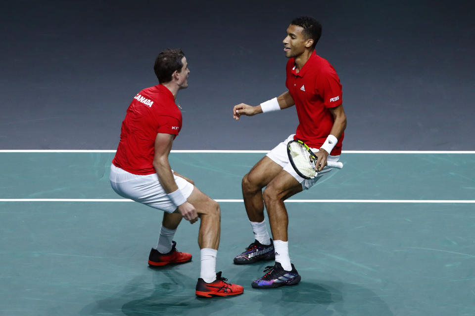 Canada's Vasek Pospisil, left, and Felix Auger Aliassime celebrate after defeating Italy's Matteo Berrettini and Fabio Fognini during the semi-final Davis Cup tennis doubles match between Italy and Canada in Malaga, Spain, Saturday, Nov. 26, 2022. (AP Photo/Joan Monfort)