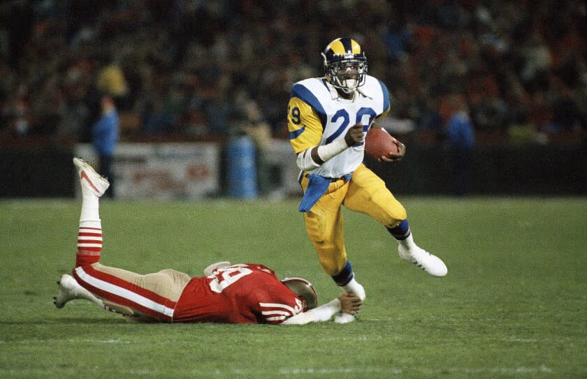 Los Angeles Rams running back Eric Dickerson right, keeps going with the ball as San Francisco 49ers linebacker Mike Walter.