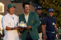 Hideki Matsuyama, of Japan, holds his trophy with his caddie Shota Hayafuji after winning the Masters golf tournament on Sunday, April 11, 2021, in Augusta, Ga. (AP Photo/David J. Phillip)