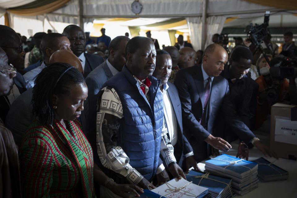 Presidential candidate Raila Odinga, center, hands over the petition to the Supreme Court challenging the election results, accompanied by running mate Martha Karua, left, in Nairobi, Kenya Monday, Aug. 22, 2022. Odinga filed a Supreme Court challenge to last week's election result, asserting that the process was marked by criminal subversion and seeking that the outcome be nullified and a new vote be ordered. (AP Photo/Ben Curtis)