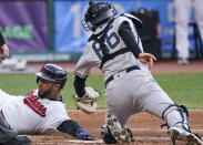 Cleveland Indians' Eddie Rosario, left, slides safely into home plate as New York Yankees' Kyle Higashioka is late on the tag in the first inning of a baseball game, Thursday, April 22, 2021, in Cleveland. (AP Photo/Tony Dejak)