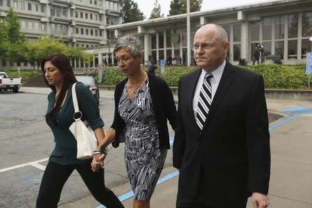 Bart and Leslie Tichelman join hands with their daughter, Monica, after attending the arraignment of their daughter, Alix Catherine Tichelman in Santa Cruz, California July 16, 2014. REUTERS/Robert Galbraith