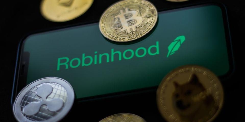 Robinhood logo displayed on a phone screen and representation of cryptocurrencies are seen in this illustration photo taken in Krakow, Poland on June 29, 2021