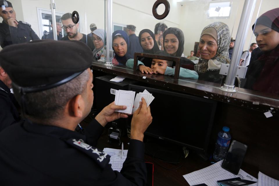 Palestinians with dual nationality register to cross to Egypt on the Gaza Strip side of the border crossing in Rafah (Hatem Ali/AP) (AP)