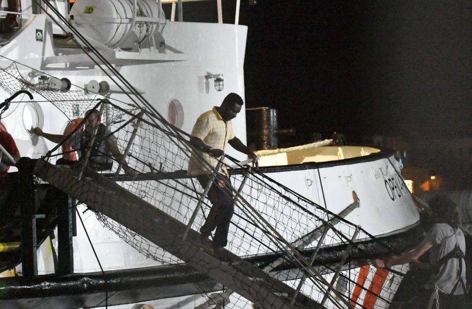 A man disembarks from the Open Arms rescue ship on the Sicilian island of Lampedusa, southern Italy, Tuesday, Aug. 20, 2019. An Italian prosecutor ordered the seizure of a rescue ship and the immediate evacuation of more than 80 migrants still aboard, capping a drama Tuesday that saw 15 people jump overboard in a desperate bid to escape deteriorating conditions on the vessel and Spain dispatch a naval ship to try to resolve the crisis. (AP Photo/Salvatore Cavalli)