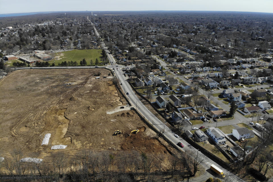 A plot of land that is being developed into multifamily housing, bottom left, is seen in East Northport, N.Y., Thursday, March 16, 2023. Some elected officials from Long Island claim their suburban way of life is threatened by New York Gov. Kathy Hochul's plan to spur more housing construction. They claim it would swamp the area with new apartment buildings and turn it into a "sixth borough" of the city. (AP Photo/Seth Wenig)