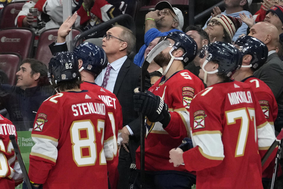 Florida Panthers coach Paul Maurice, center, acknowledges the crowd as a video tribute is played acknowledging the number of games he has coached in the NHL, during the first period of the team's hockey game against the Arizona Coyotes, Wednesday, Jan. 24, 2024, in Sunrise, Fla. (AP Photo/Lynne Sladky)