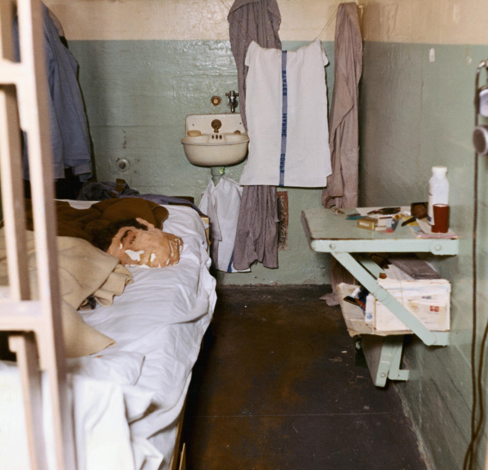 A shot of one of the escapees jail cells with the dummy head laying on the bed and the escape window the cut out hidden by some fabric