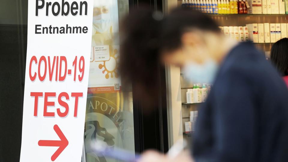 Eine Frau füllt vor einer Apotheke ein Formular für einen Covid-19-Test aus.(Symbolbild: dpa)