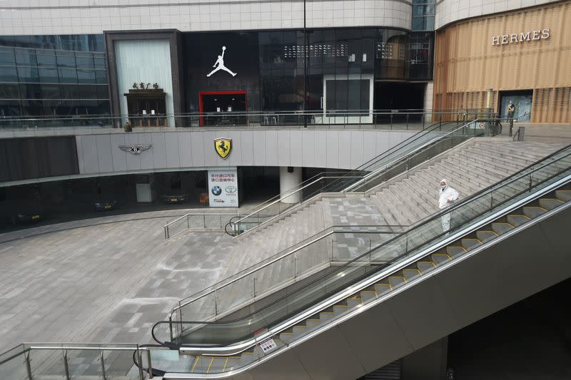 Man in protective suit stands at a shopping mall in Wuhan, the epicentre of the novel coronavirus outbreak