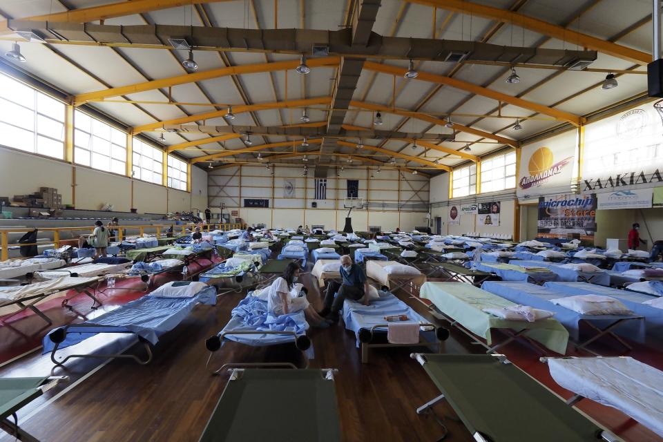 People who fled their homes during wildfires are accommodated at an indoor hall in Chalkida the capital of Evia island, about 81 kilometers (50 miles) north of Athens, Greece, Saturday, Aug. 7, 2021. Wildfires are rampaging through some of Greece's last remaining forests for yet another day, encroaching on more inhabited areas after burning scores of homes, businesses and farms during the country's worst heat wave in three decades. (AP Photo/Thodoris Nikolaou)