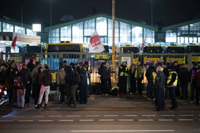 Strikers stand in front of a BVG bus depot in Müllerstrasse. Over 80 cities were called to go on a warning strike as part of the nationwide wage dispute in regional negotiations by the Verdi trade union. Sebastian Christoph Gollnow/dpa