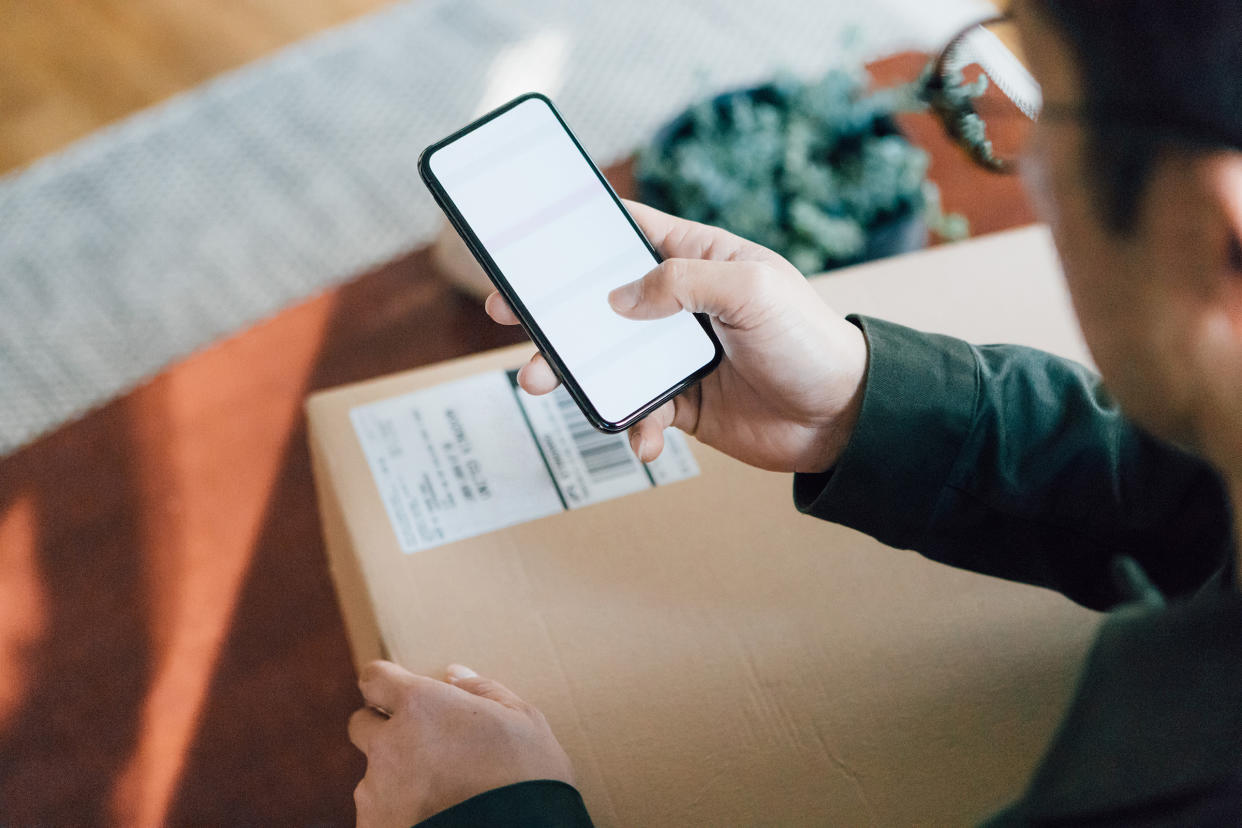 Close up shot of man shopping online with mobile phone at home